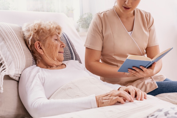 women being read to in memory care facility